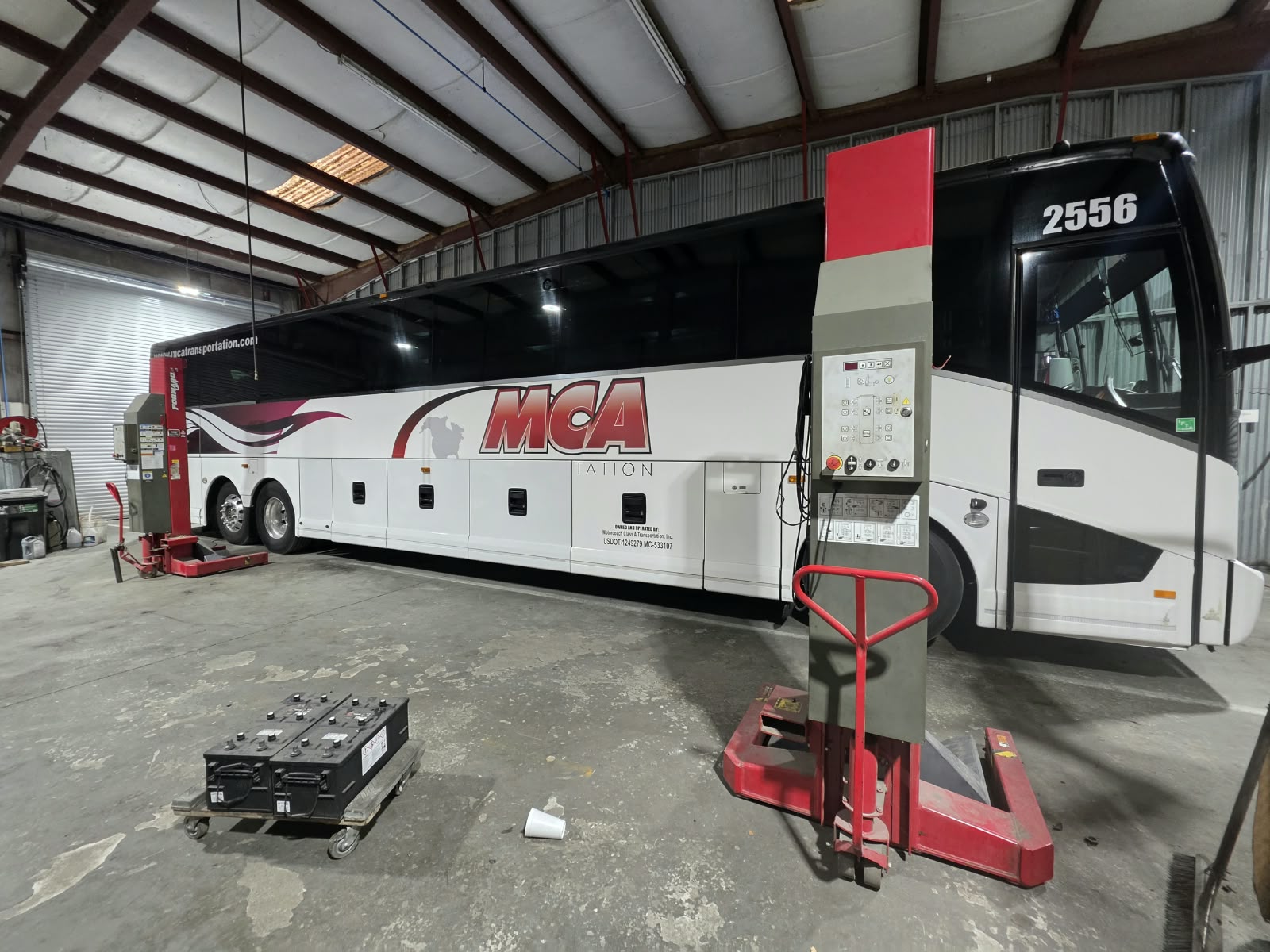 MCA Transportation motorcoach on a vehicle lift inside the complete shop