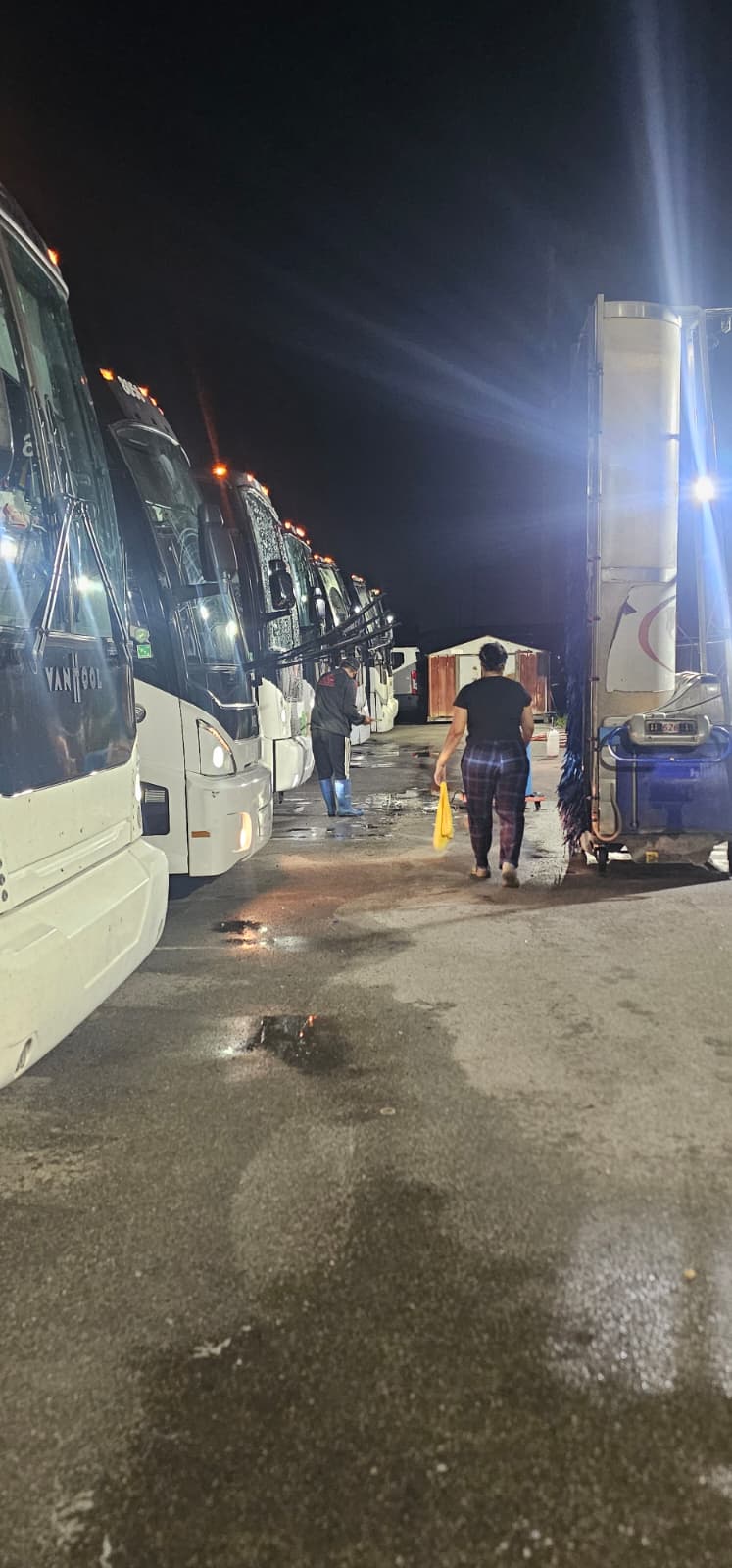MCA Transportation overnight crew cleaning a line of motorcoaches