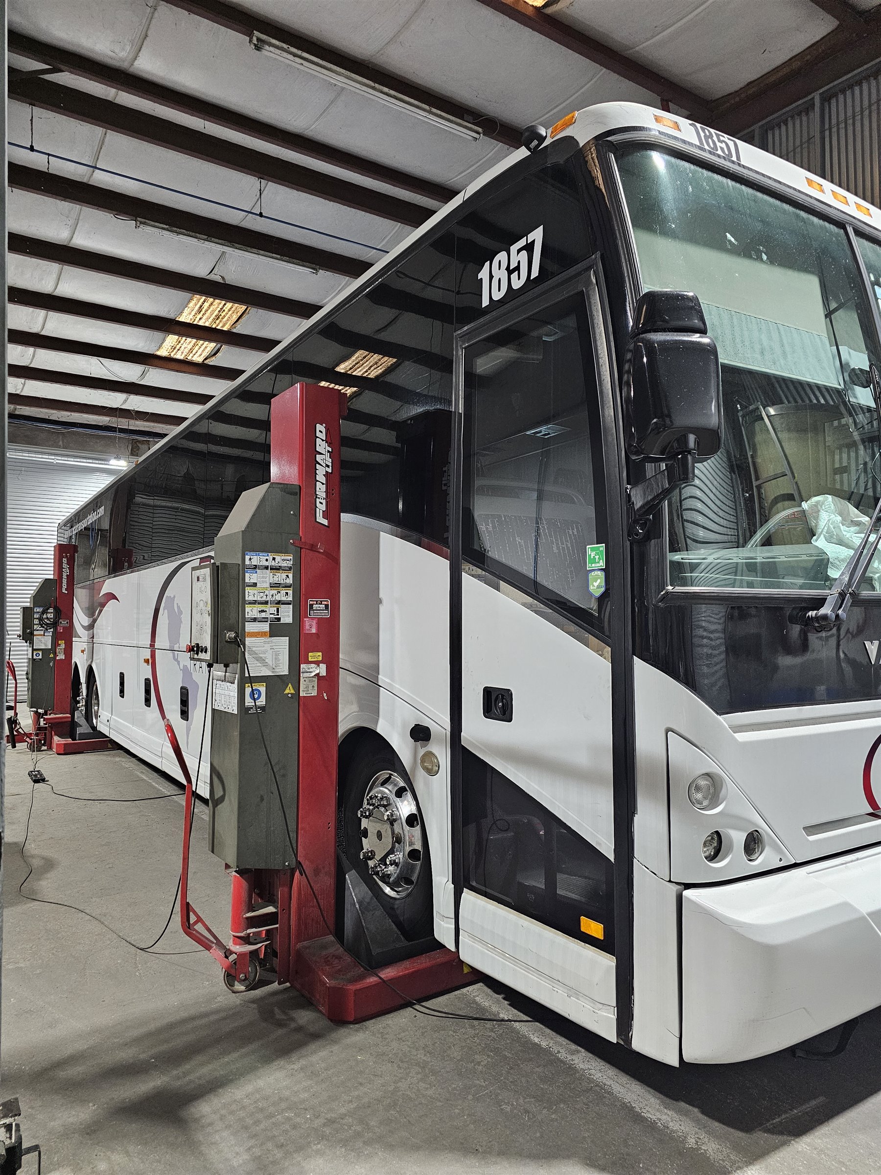 MCA Transportation motorcoach on a lift in the maintenance shop