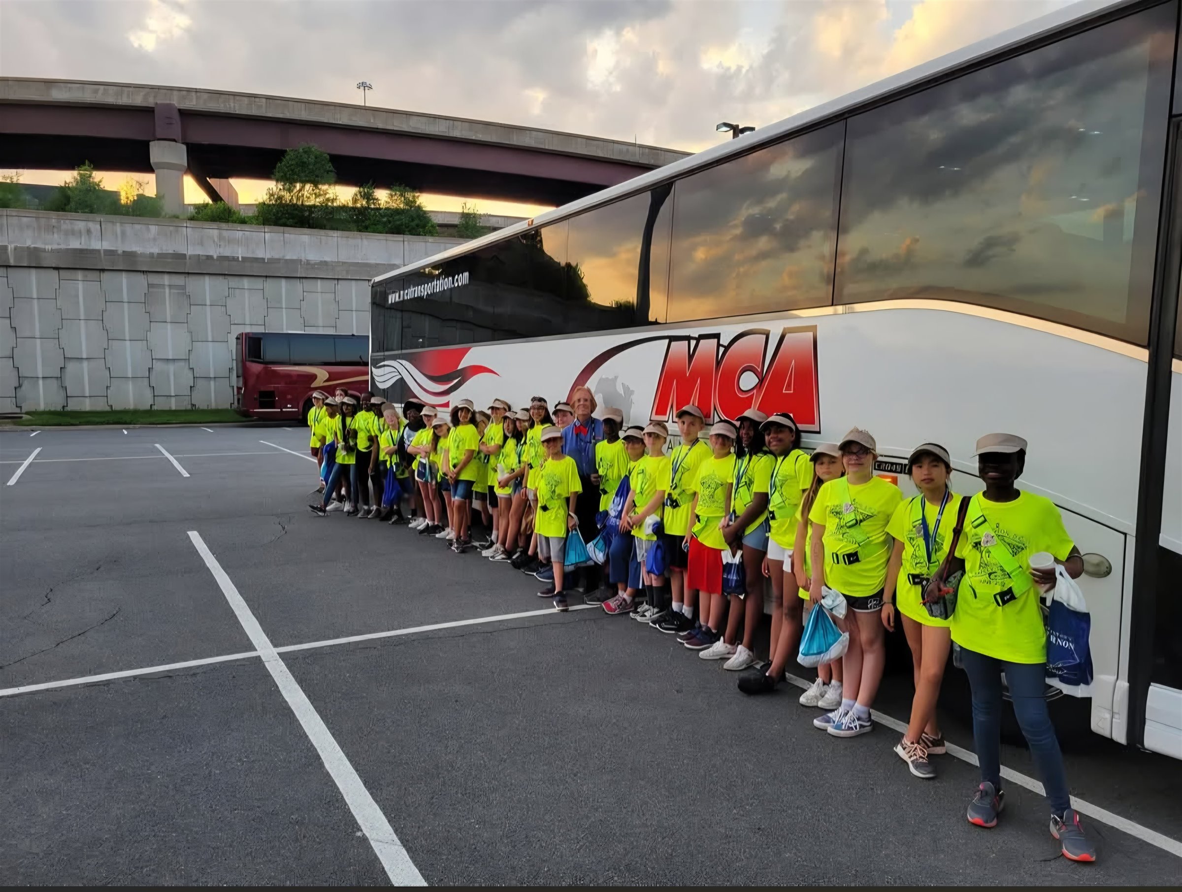 Student group beside an MCA Transportation motorcoach