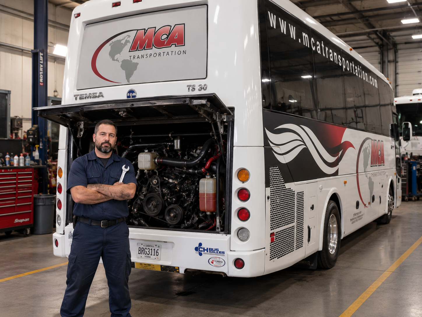 MCA master mechanic standing beside a coach in the maintenance shop